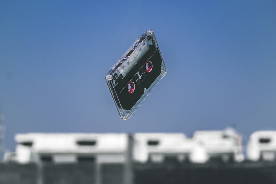 A retro cassette tape floats in mid-air with a blurred urban background, symbolizing nostalgia.